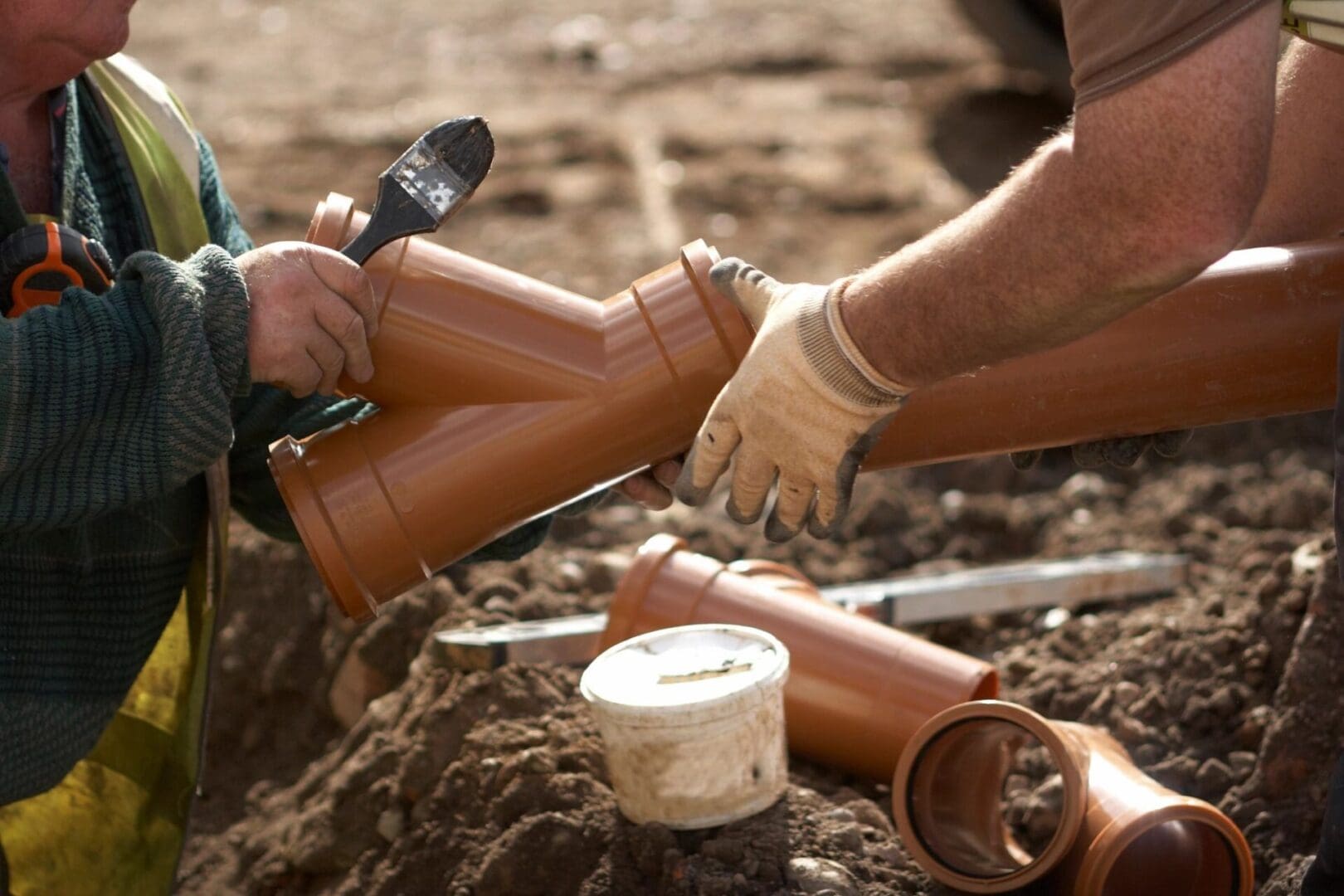 A person in white gloves is holding a pair of boots.