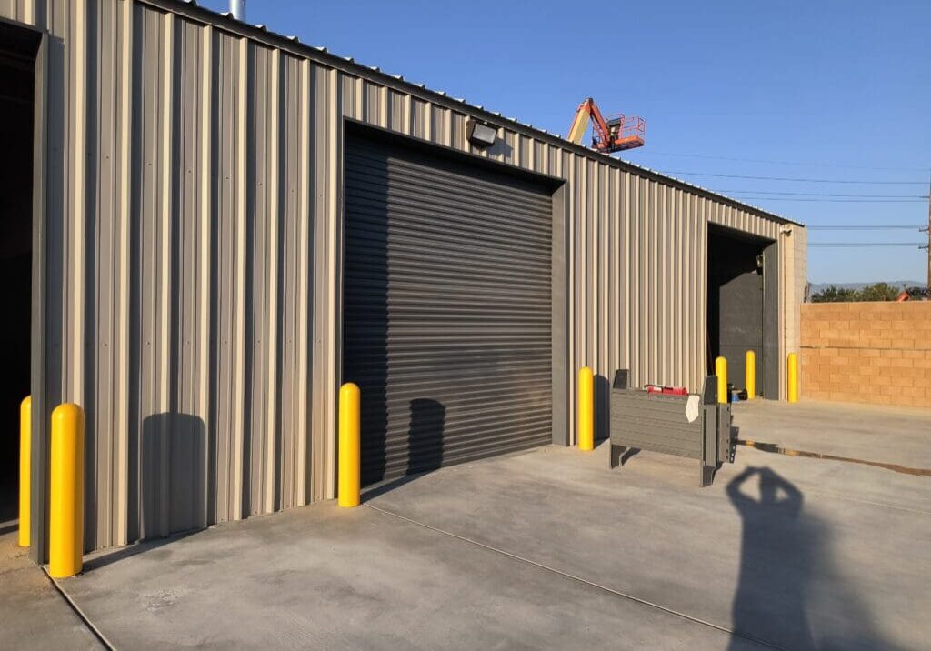 A large building with two doors and yellow posts.